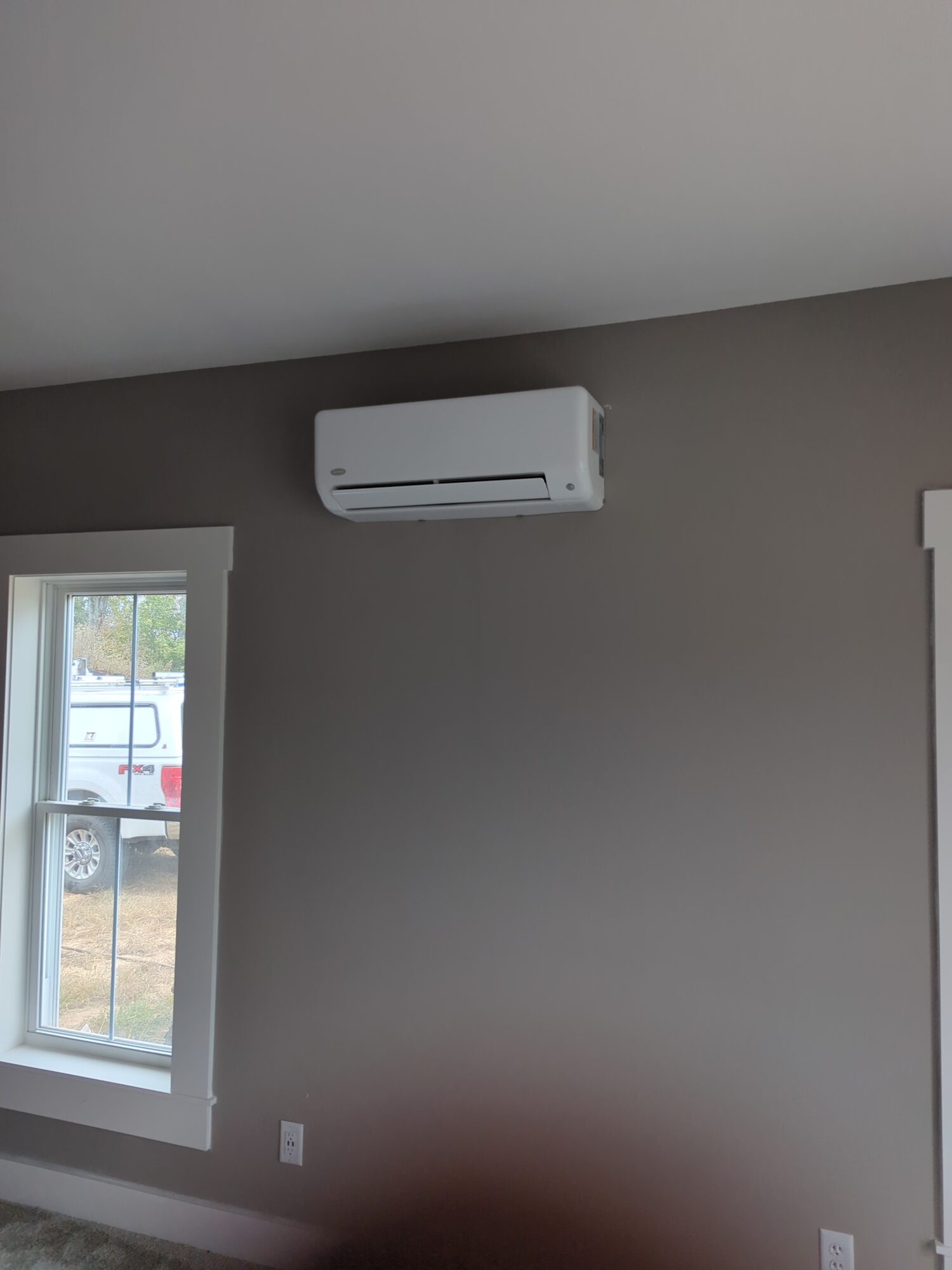 Carrier ductless mini-split indoor unit on a bedroom wall in a newly built home